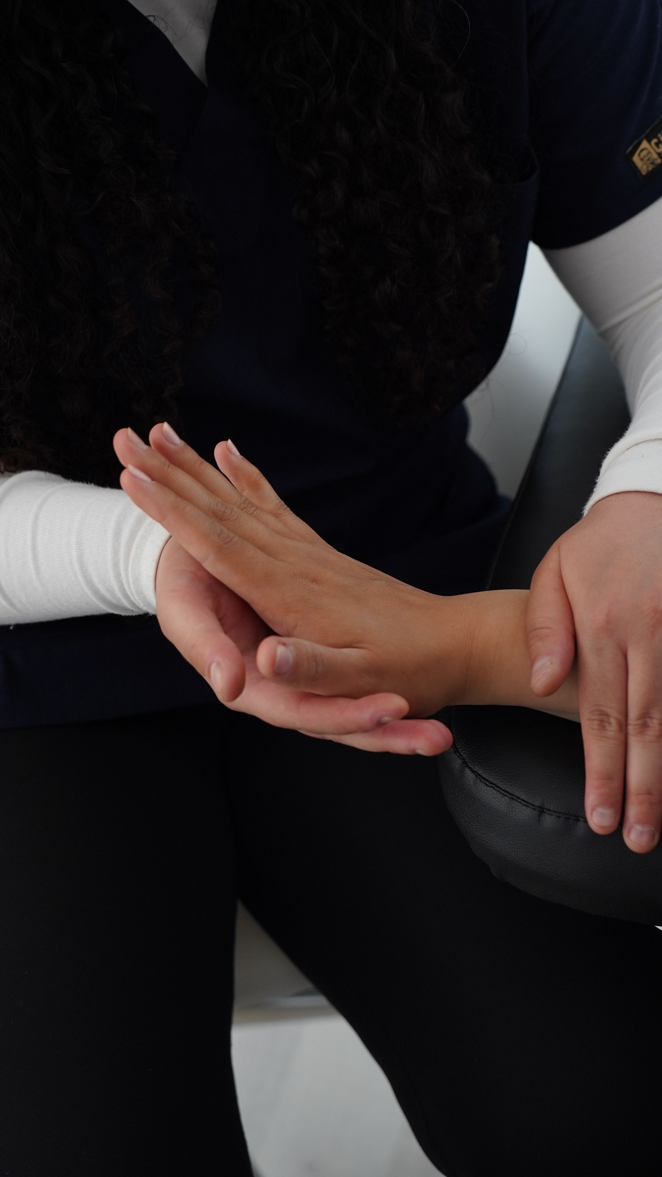 Physiotherapist assessing a client's wrist and hand